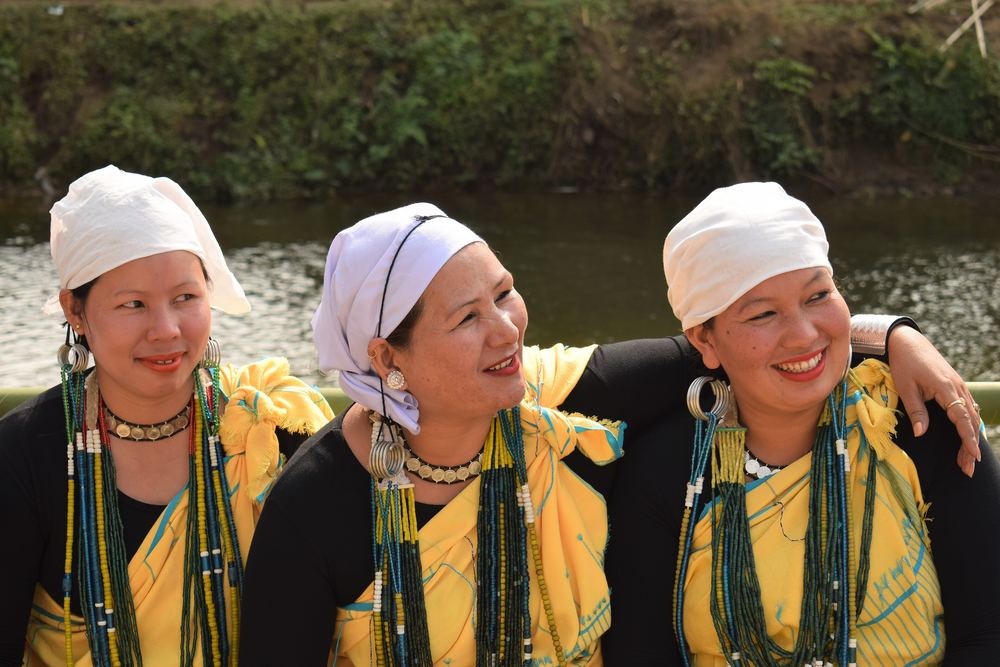 Three smiling Galo women in white headscarves
